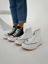 Championes tipo botita de caña alta con diseño bicolor, cuerpo en color negro y suela de plataforma gruesa en color blanco con base de goma.