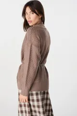 Saco abierto de punto color blanco, con diseño de textura cuadriculada en las mangas y corte holgado.