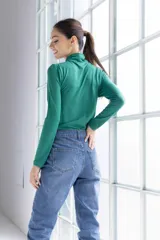 Polera verde esmeralda de cuello alto con detalle drapeado en el cuello, corte ajustado y mangas largas.