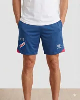 Short de fútbol Umbro del Club Nacional de Football, modelo Home 2025. Diseño en color azul con detalles en rojo en los laterales y el escudo del club junto al logo de la marca.