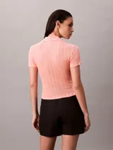 Chomba de manga corta Calvin Klein confeccionada en tejido de punto pointelle texturizado. Presenta un cuello tipo Johnny abierto y ribetes en punto canalé.