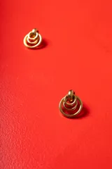 Aros de diseño geométrico formados por tres círculos concéntricos de metal dorado pulido, con cierre de perno.