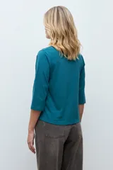 Remera de manga tres cuartos con escote en V, confeccionada en tela con textura de broderie en el frente.