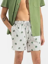 Short de baño celeste con rayas verticales blancas y estampado de flores blancas.