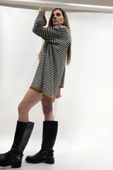 Vestido corto tejido a rayas horizontales blancas y negras, con cuello alto y mangas largas.