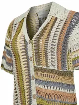 Sweater de crochet modelo Lenka, confeccionado con mezcla de algodón orgánico y lino. Presenta diseño de rayas verticales en la parte superior y horizontales en la inferior, con cuello camisero, mangas cortas y cierre frontal de botones.