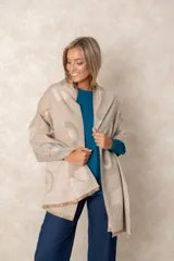 Pashmina de textura suave con diseño reversible de hojas tipo ginkgo biloba en tonos beige, verde y naranja. Presenta flecos cortos en los extremos y una caída fluida.