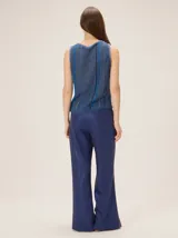 Pantalón de lino color azul metalizado, de corte sastrero, tiro medio y pierna recta amplia.