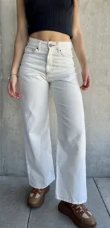 Pantalón jean de tiro alto color blanco, corte recto y pierna ancha.