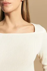 Remera de tejido acanalado (rib) color blanco, con escote cuadrado y mangas tres cuartos, de ajuste entallado al cuerpo.