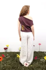 Top de algodón color bordó con escote asimétrico tipo bote y detalle de ribete en color amarillo en las mangas. Diseño de corte holgado.