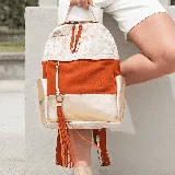 Mochila de cuero vacuno color naranja, blanco y dorado. Tiene un bolsillo con cierre al frente, y un bolsillo a cada lado. Su interior está forrado en tela de excelente calidad, y contiene un bolsillo con cierre y otro pequeño para el guardado del móvil.