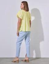 Blusa amarilla con textura labrada, escote redondo elastizado y mangas cortas con aberturas y lazos.