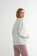 Buzo de tejido de punto en color beige jaspeado, con cuello redondo y detalles de costura en contraste en el cuello y el ruedo.