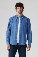 Camisa de manga larga de denim azul claro, con cuello abotonado (button-down) y botones frontales blancos.