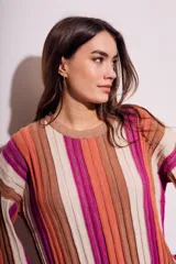 Sweater de punto con rayas verticales en tonos beige, naranja, marrón y fucsia.
