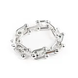 Pulsera plateada con eslabones de metal en forma de U unidos por esferas.