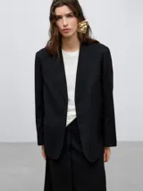 Blazer sastre negro tejido de lana merino, sin solapa y sin bolsillos, de largo bajo cadera y efecto emboss.