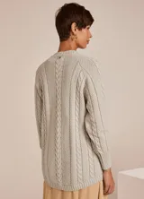Sweater tejido en punto color gris claro, con cuello redondo y manga larga. Presenta diseño de trenzas en el frente y terminaciones acanaladas.