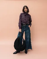 Cartera tipo hobo de gran tamaño, confeccionada en gamuza negra con detalle de costuras artesanales en el borde y asa trenzada. Cuenta con cierre superior y un diseño amplio y relajado.