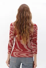 Polera de tejido de punto con diseño vanizado que combina tonos tierra y crema en un patrón abstracto de líneas onduladas. Presenta cuello alto, mangas largas y un ajuste entallado al cuerpo.