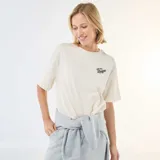 Camiseta de corte oversize color blanco crudo, con cuello redondo y mangas cortas. Presenta un pequeño estampado tipográfico en el pecho con la frase 'East Side League'.