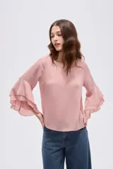 Blusa negra de poliéster, con cuello redondo, mangas 3/4 con volados en capas y diseño holgado.