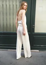 Pantalón recto de tiro medio color beige, con bolsillos laterales y un cinturón incorporado con detalle de flecos en los extremos.