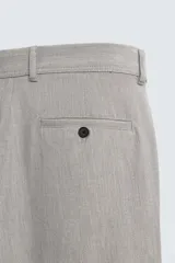 Pantalón chino de corte slim fit, confeccionado en tejido elástico. Presenta bolsillos frontales, bolsillos traseros de vivo con botón y cierre frontal con cremallera y botón.