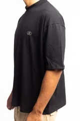 Remera negra de corte boxy con cuello subido y logo bordado en el pecho.