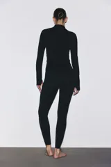 Campera deportiva de corte ajustado en tejido funcional con tecnología de absorción de sudor. Presenta cuello elevado, cierre frontal completo, mangas raglán extralargas con abertura para el pulgar y bolsillos laterales con cierre.