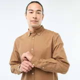 Camisa de corte regular fit en tejido oxford color marrón, con cuello abotonado y cierre frontal de botones.