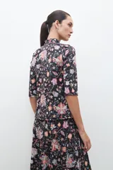 Polera negra con estampado floral estilo búlgaro, cuello alto y mangas 3/4.