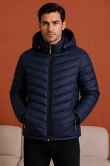 Campera puffer con capucha, cierre frontal completo y bolsillos laterales con cierre. Diseño acolchado con costuras horizontales.