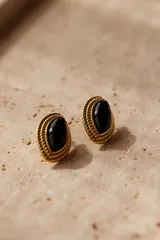 Aros tipo caravana de acero quirúrgico hipoalergénico color dorado con forma de ojo y piedra negra engarzada.