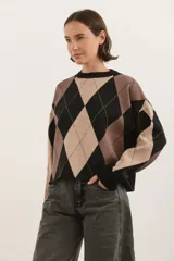 Sweater de tejido bremer con diseño de rombos en tonos negro, beige y marrón. Presenta cuello redondo, mangas largas y un corte holgado.