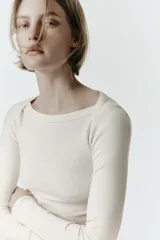 Camiseta de manga larga con cuello barco y bajo recto, confeccionada en tejido de punto liso.