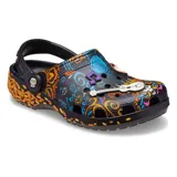 Zuecos de goma color negro con diseño estampado inspirado en la película Coco, con detalles alegóricos al Día de Muertos, pétalos de caléndula, elementos musicales y correas traseras con pivotes decorativos.