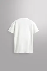 Camiseta de corte relajado confeccionada en tejido de algodón pesado, con cuello redondo y manga corta.