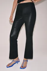 Pantalón de tiro medio confeccionado en piel 100%, con diseño de corte flare o evasé en el bajo y cierre de cremallera oculta en la costura lateral.