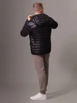 Campera acolchada Calvin Klein color negro, con capucha, cierre frontal con cremallera y bolsillos laterales con cremallera.