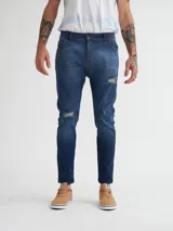 Pantalón de jean azul con roturas en las rodillas, corte skinny y tiro medio.