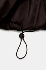 Anorak acolchado de corte corto, resistente al agua y al viento. Cuenta con cuello subido, capucha ajustable con cordones, cierre frontal con cremallera y bolsillos laterales con forro polar. El bajo es ajustable mediante cordones elásticos.