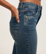 Pantalón de jeans celeste, modelo flare cropped, con trabillas en la cintura, bolsillos y terminación deshilachada.