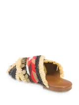 Sandalia plana con tiras cruzadas de rafia color beige, con aplicaciones de mostacillas de colores y monedas doradas.