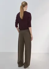 Cardigan de punto fino color bordó, de diseño recto, con cuello redondo, manga larga y cierre frontal con botones.