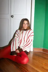 Sweater tejido a mano con lana merino color crudo, con bordado en relieve de rayas rojas tipo cadenas. Puños y cuello en marrón con lurex.