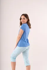 Pijama de dos piezas color coral, compuesto por una remera de manga corta con botones y un pantalón capri estampado con flores.