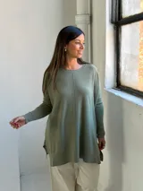 Sweater de tejido de punto color verde oliva, con cuello redondo, mangas largas y corte holgado con costura central vertical.