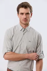 Camisa lisa de manga larga de algodón en color gris claro, de corte slim fit con cuello camisero y cierre frontal de botones.